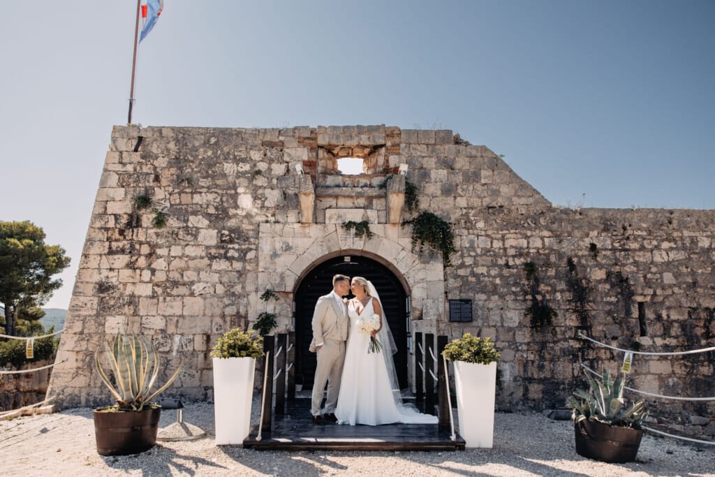 newlyweds in front of old building