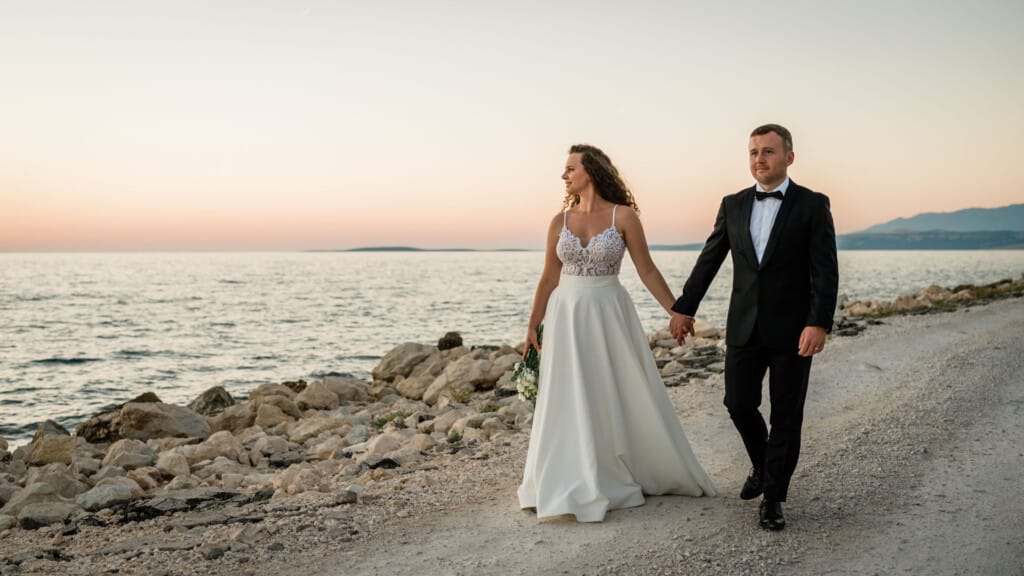 newlyweds walking by the sea